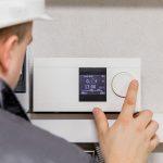 HVAC tech repairing thermostat