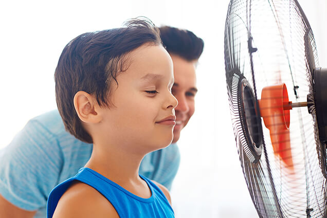 boy with face in front of the fan
