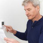 St. Louis man adjusting thermostat